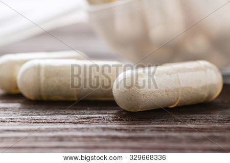 White Medical Capsules Of Glucosamine Chondroitin, Healthy Supplement Pills On Wooden Background, Ma