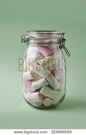 Jar With Marshmallows In Pastel Color On Lightgreen Background
