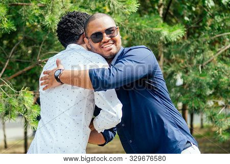 Two Stylish Young Friends Hugging Long-awaited Meeting In Street Parking