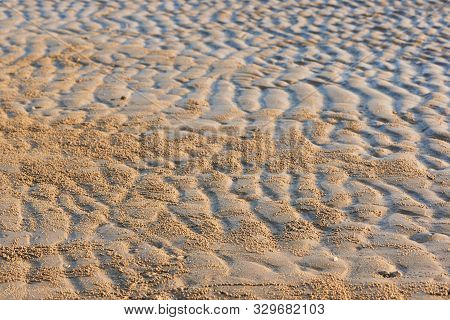 Background Pattern Of Seawaves On The Beach During Low Tide