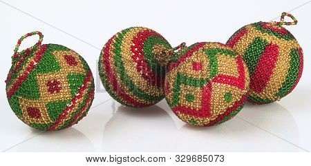 A Picture Of Four Red Green And Gold Colourful Beaded Balls Christmas Tree Decorations