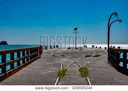 Fishing Off The End Of The Long Historic Pier At Tolaga Bay In New Zealand