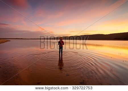 Watching With Awe And Wonder The Sunset And Its Magnificent Reflections In The Water In Rural Austra