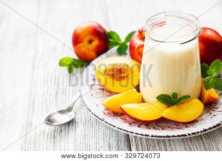 Yogurt With Fresh Nectarines On A White Wooden Table