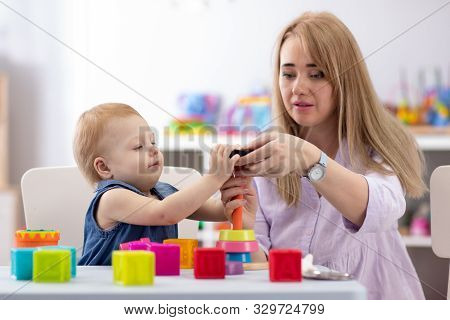 Baby Play With Babysitter Or Mom In Nursery Or Kindergarten