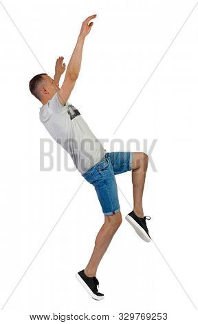 Side view of a man dancing in shorts. The guy is balancing. Rear view people collection. backside view of person. Isolated over white background. A guy in denim shorts falls to his back.