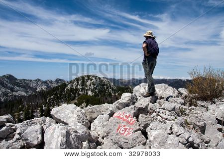 Uomo guarda dall'alto della collina su altre montagne