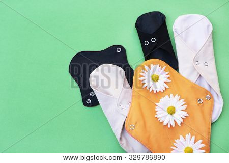 Reusable Fabric For Women Menstruation Pads With Daisies On A Green Background. Zero Waste Concept. 