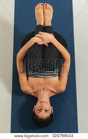 woman in knees to chest pose