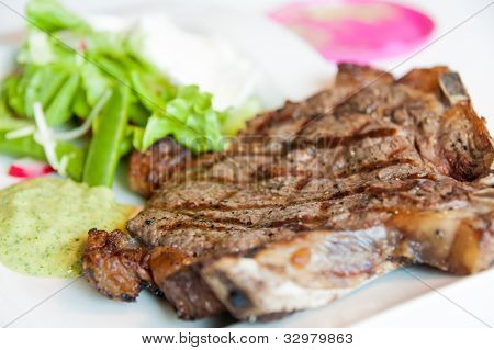 Bøf med mærker på en hvid plade med nogle Sallad