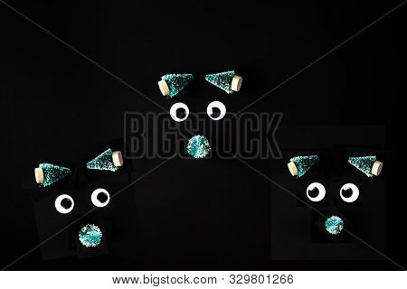Funny Faces Made From Jiggly Eyes And Little Fir Tree On Black Background