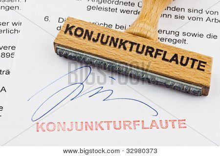 un francobollo in legno sdraiato su un documento. Parole tedesche: crisi economica
