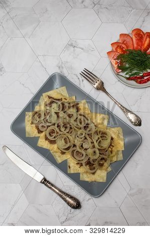 Beshbarmak Is A National Kazakh Dish - Square Pasta With Boiled Meat And Onions. On A Light Backgrou