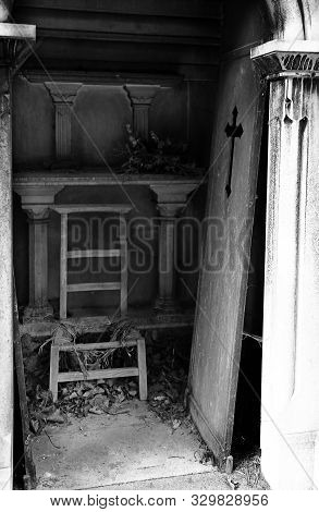 Unhinged Door And Broken Chair On Burial Plot Of The Cemetery