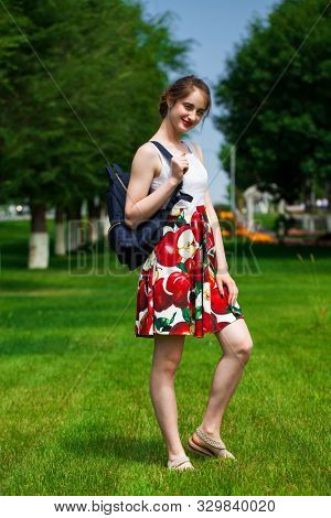 Close up, Young beautiful brunette girl in summer dress walks in the park