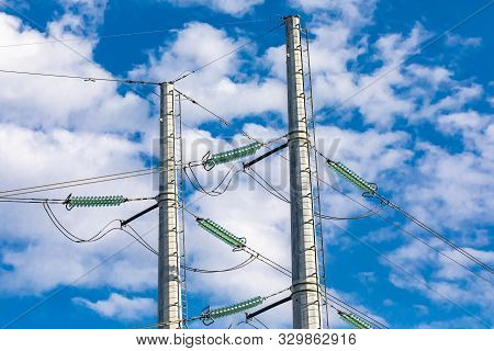 A Closeup View On The Top Half Of A Double Poled Electric Pylon Supporting Medium Voltage Cables Wit