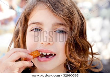 Occhi blu bambina mangiare krapfen fritti churros sorridente