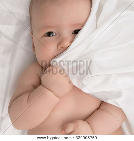 Baby Boy Lying On White Linen Studio Shot