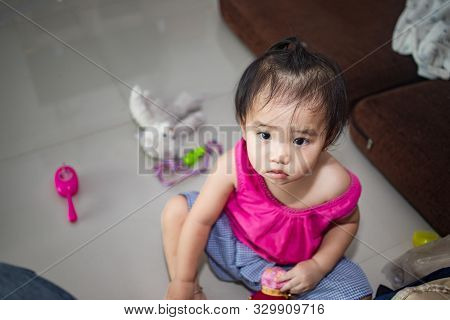 Little Adorable Girl Sitting And Playing In Living Room