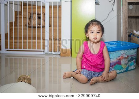 Little Adorable Girl Sitting And Playing In Living Room