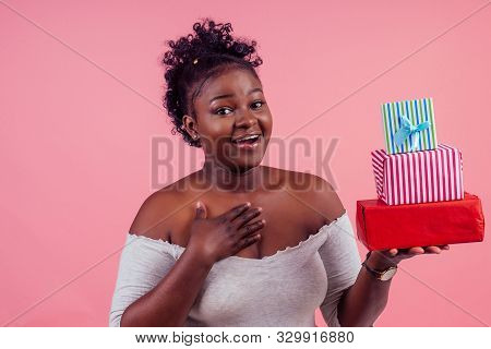 Happy Afro Woman Holding Gift Boxes March 8 In Stusio Pink Background