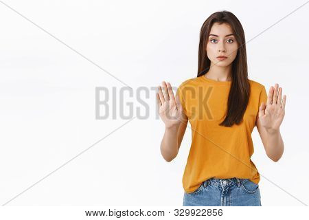 Serious-looking Confident Good-looking Woman In Yellow T-shirt, Raising Hands In Stop, Taboo Or Proh