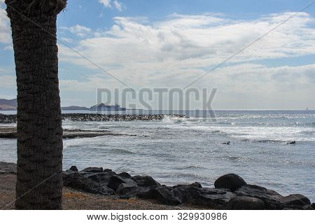 Stony Beach At Playa De Las Americas On Canary Island Tenerife With Blue Water, Blue  Sky With White