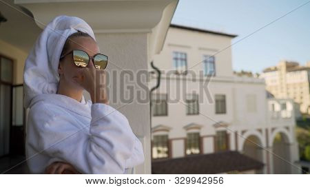 A Girl In A White Robe Stands On The Balcony And Enjoys. Sexy Girl In White Robe Stands On The Balco