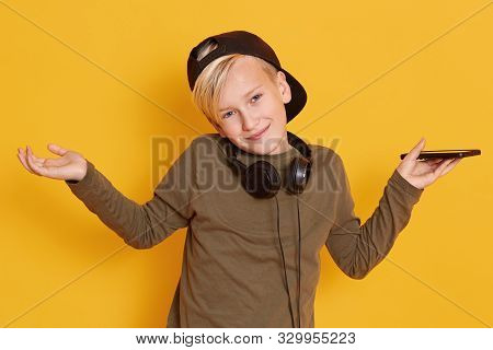 Portrait Of Smiling Happy Kid Standing With Hands Spread Wide Isolated Over Yellow Background, Cute 