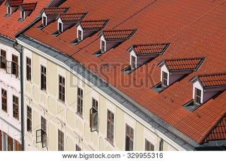 Top View Of Old Building With Red Roof And Windows On The Roof. European City, View From Elevation P