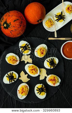 Halloween Stuffed Eggs With Cheese And Mustard On A Black Stone.