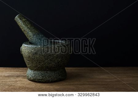 Stone Mortar On The Wooden Table,black Background With Copy Space