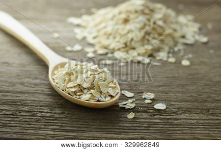 Oatmeal Or Oat Flakes In The Wooden Spoon On Wooden Table.selective Focus