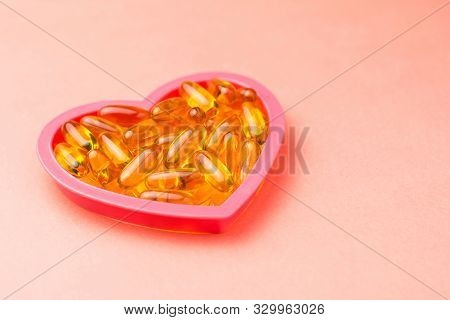 Fishoil Capsules In The Heart Shape Frame On Pink Background With Copy Space.