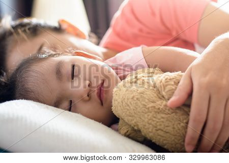 Close Up Cute Asian Baby Girl And Her Mother Sleeping On The Bed.side View