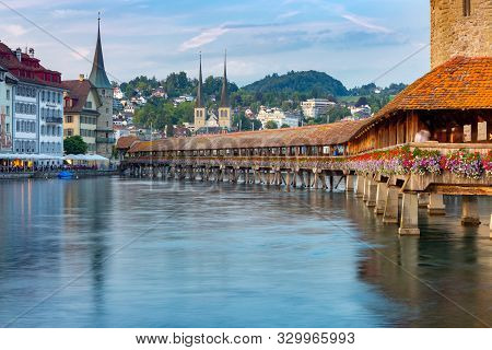 Scenic View Of The Chapel, Kapellbrucke Bridge, Wasserturm Tower In The Lantern Light At Sunrise. Lu