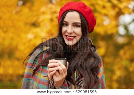 Portrait Of Beautiful Brunette Girl Walking In Firest Or Park, Keeping Hot Baverage In One Hand, Enj