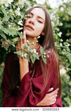 A Beautiful Gypsy With An Expression Of Languor And Pleasure Touches Her Cheek On A Flowering Tree B