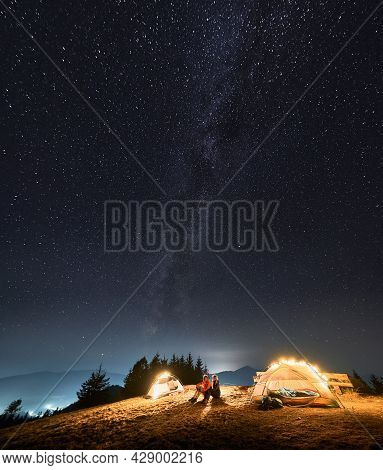 Two Campers Looking On Evening Scenery Endless Sky Covered With Stars And Milky Way Galaxy From Moun