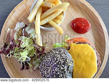 The Fast American Food Cheese Hamburgar With Fries And Salad On The Wooden Tray