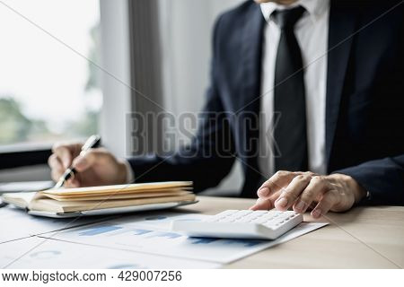 Businessman Takes Notes On A Topic That Examines Information From Finance Documents To Bring To Depa