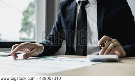 A Businessman Is Reviewing Information From Finance Documents To Bring To Department And Partnership