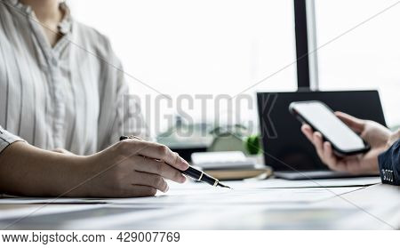 Two Businessmen Are Brainstorming Together And Reviewing The Company Financial Documents That The Fi