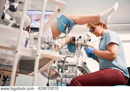 Female Gynecologist Examining Patient With Colposcope In Gynecological Clinic. Woman Sitting In Chai