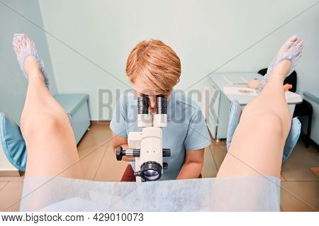 Doctor Examining Woman With Colposcope In Gynecological Clinic. Patient Sitting In Gynecological Cha