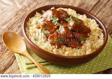 Cypriot Afelia Braised Pork In Red Wine With Bulgur Closeup In The Bowl On The Table. Horizontal