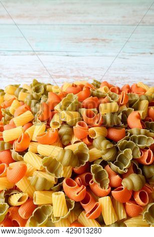 Pile Of Dried Vegeroni Pasta On Wooden Table With Copy Space
