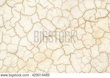 Golden Cracked Desert Soil. Arid Climate. Dry Dewatered Sandy Ground. Abstract Texture Or Background