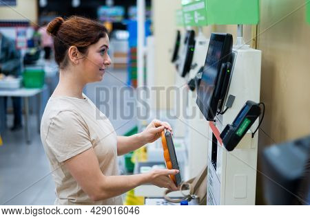 Caucasian Woman Uses A Self-checkout Counter. Self-purchase Of Groceries In The Supermarket Without 