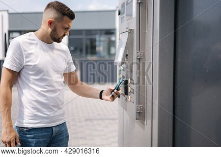 Man Put Plactic Card For Paying Outdoors On Self-service Car Wash